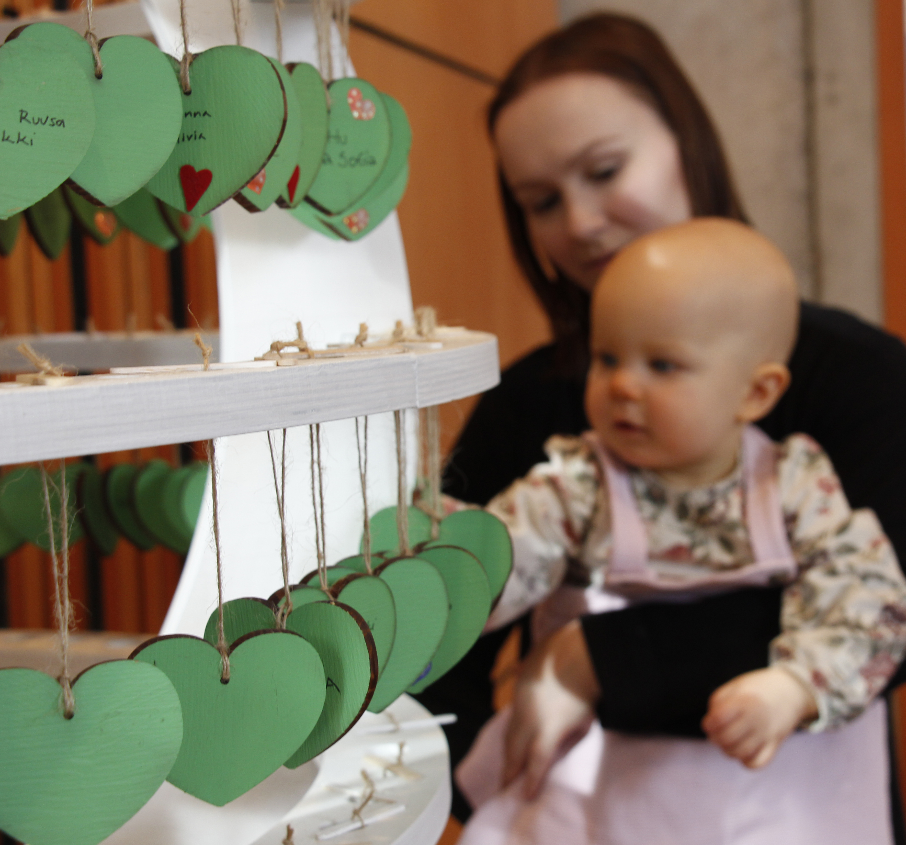 lapsi ja aikuinen katselemassa kastepuunlehtiä