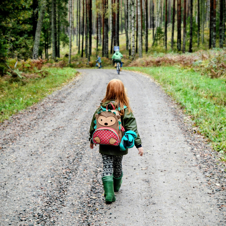 lapsi kävelee reppuselässä